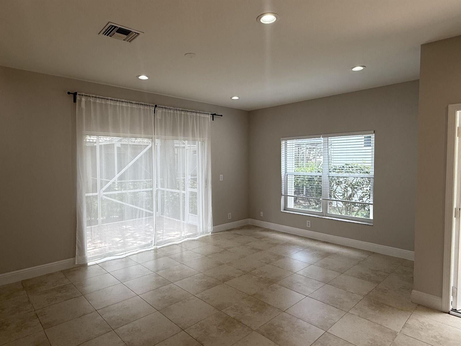 An empty room with tile flooring, recessed lighting, a sliding glass door, and a window — 7218 Panache Way, Boca Raton FL 33433, BOCA RATON, FL