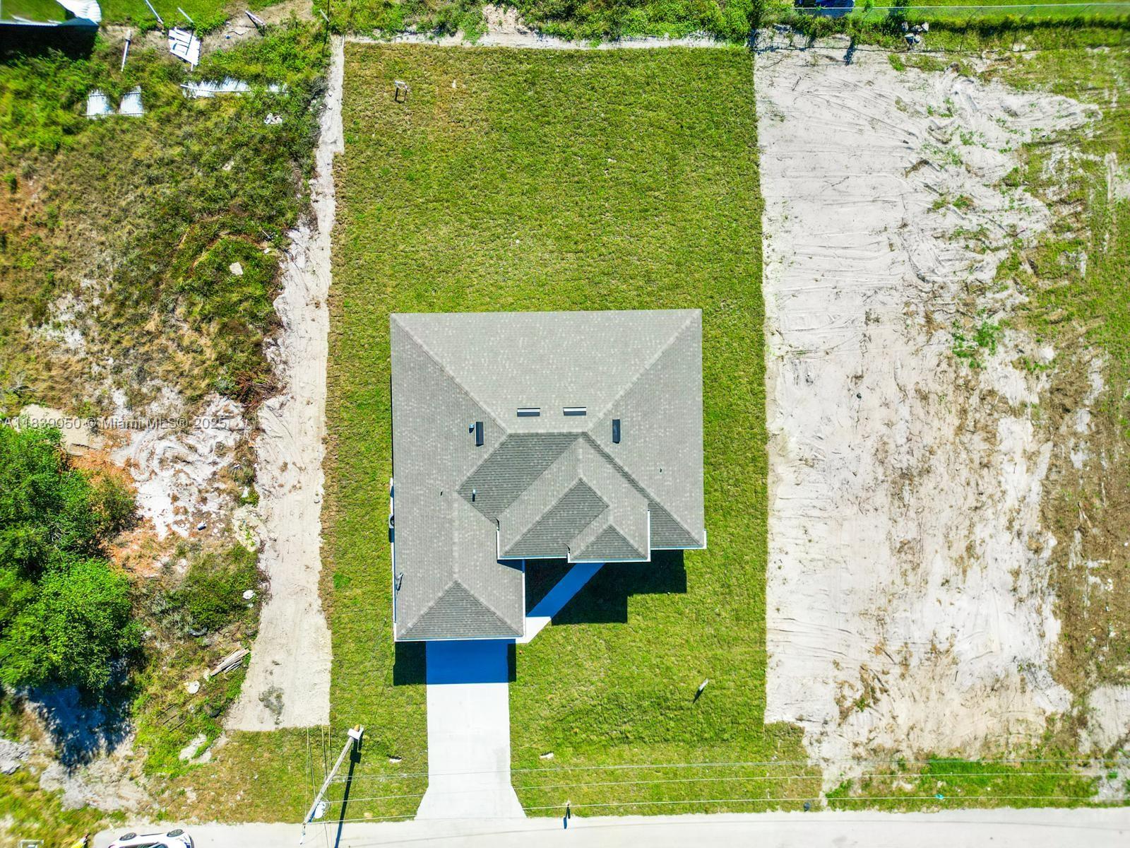 An aerial view shows a single-family home centered on a rectangular lot with surrounding grass — 2803 44TH ST SW, Lehigh Acres FL 33976, LEHIGH ACRES, FL