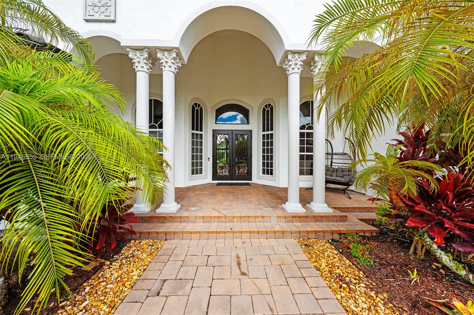The front entrance features a paved walkway, arched entryway, white columns, and double glass doors — 12401 N Stonebrook Cir, Davie FL 33330, DAVIE, FL