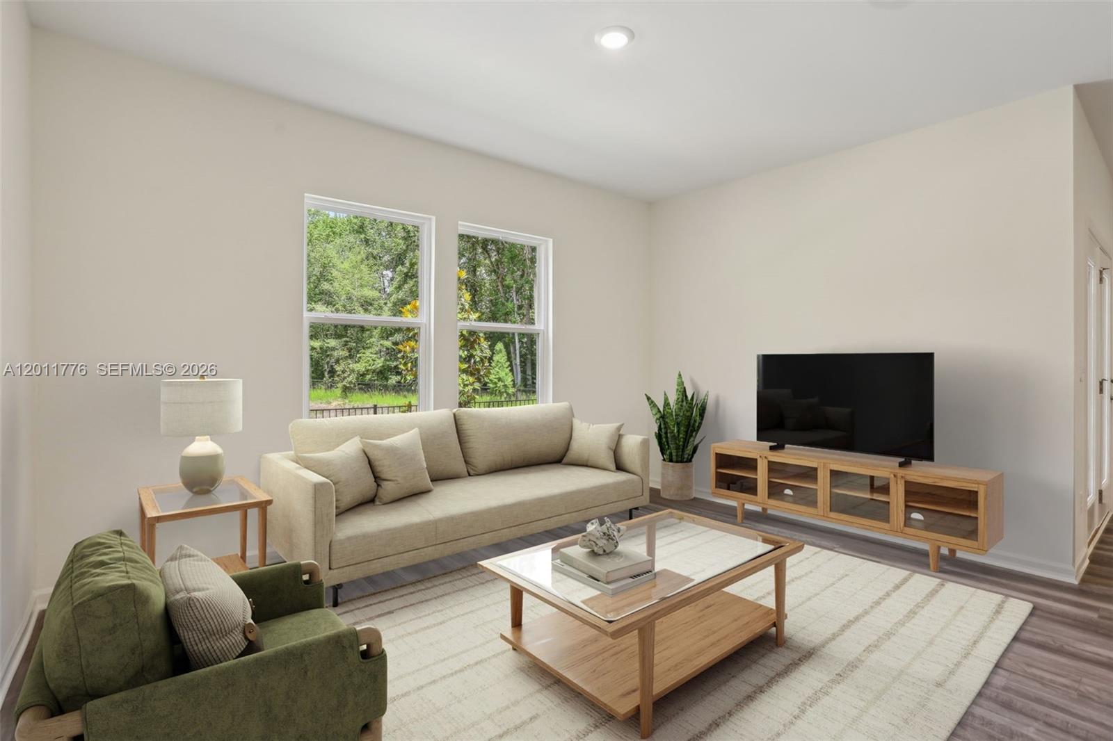 This living room features a beige sofa, a green armchair, and a glass-topped coffee table — 2571 GREY HAWK DR, Kissimmee FL 34746, KISSIMMEE, FL