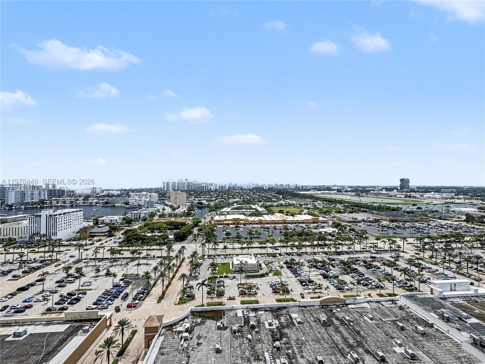 An elevated view shows a large parking lot, commercial buildings, and a distant cityscape — 1755 E Hallandale Beach Blvd # 2207E, Hallandale Beach FL 33009, HALLANDALE BEACH, FL