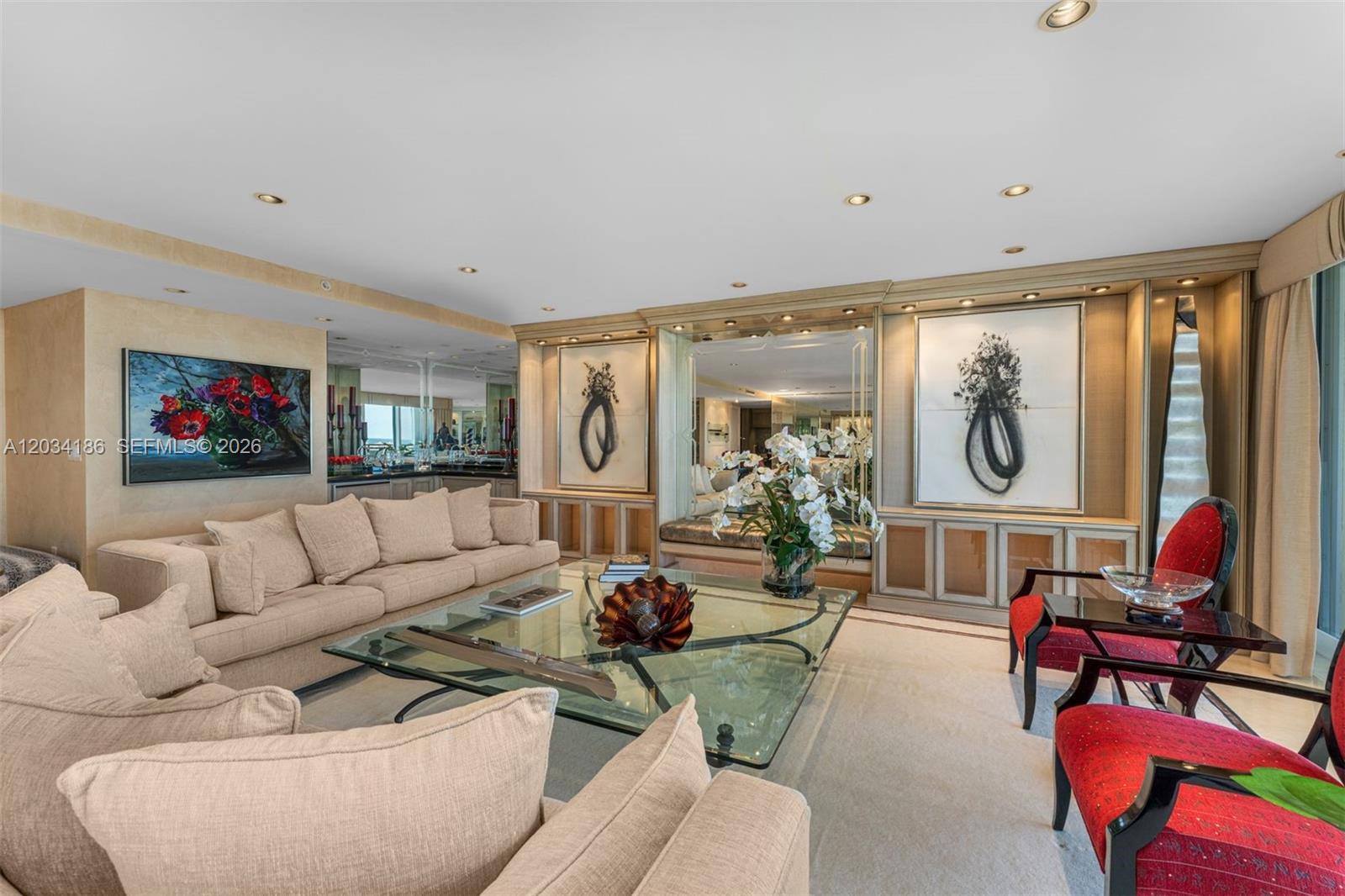 A living room features a beige sectional sofa, a glass coffee table, and red chairs — 430 Grand Bay Drive # 1103, Key Biscayne FL 33149, KEY BISCAYNE, FL