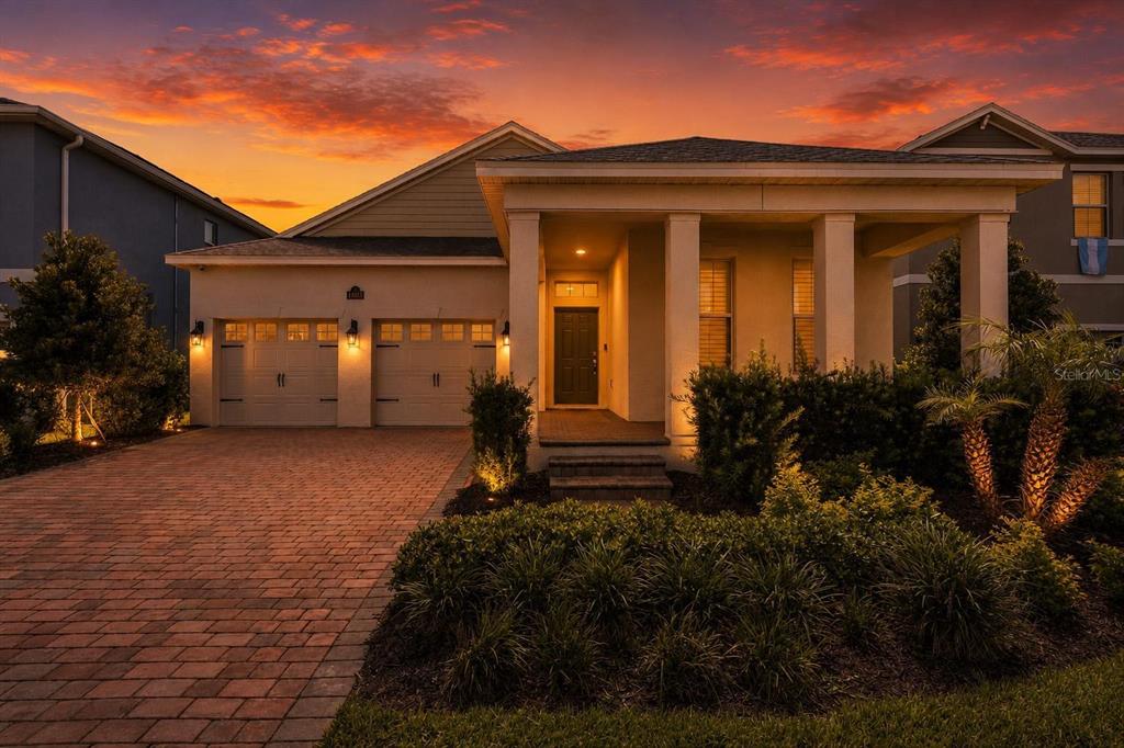 A single-story house with a brick driveway, two-car garage, and a covered front porch — 11043 JACKSON COVE, WINTER GARDEN, FL