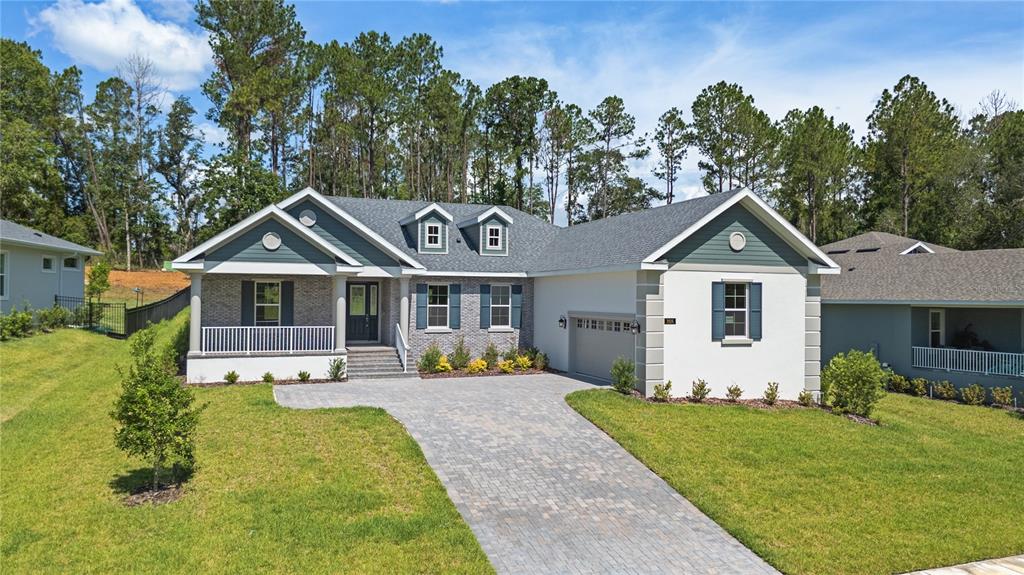 A single-story house features a brick and stucco exterior with a paved driveway and lawn — 3926 SOUTHERN VALLEY LOOP, BROOKSVILLE, FL