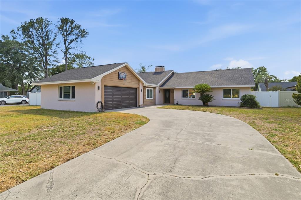A single-story house with a two-car garage, a concrete driveway, and a light-colored exterior — 11807 NICKLAUS CIRCLE, TAMPA, FL