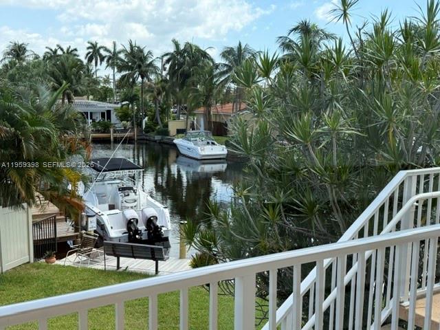 A view from a balcony overlooking a canal with two boats docked near palm trees — 301 E Mcnab Rd # 205, Pompano Beach FL 33060, POMPANO BEACH, FL