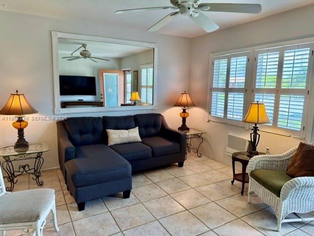 A living room features a dark sectional sofa, wicker chair, and two lamps on tables — 301 E Mcnab Rd # 205, Pompano Beach FL 33060, POMPANO BEACH, FL