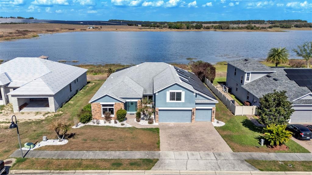 An aerial view of a blue suburban house with a gray roof and solar panels — 4530 BROOKSHIRE PLACE, LAKE WALES, FL