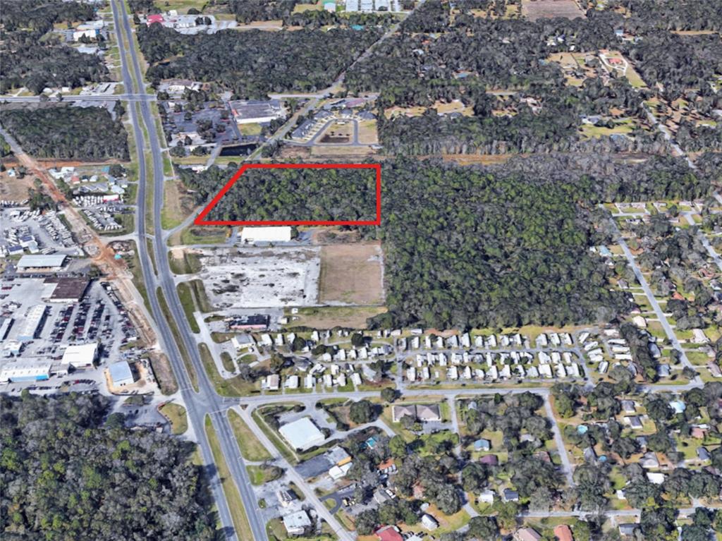 An aerial view shows a rectangular wooded lot outlined in red near a highway — HWY 441 and W ANTHONY RD, OCALA, FL