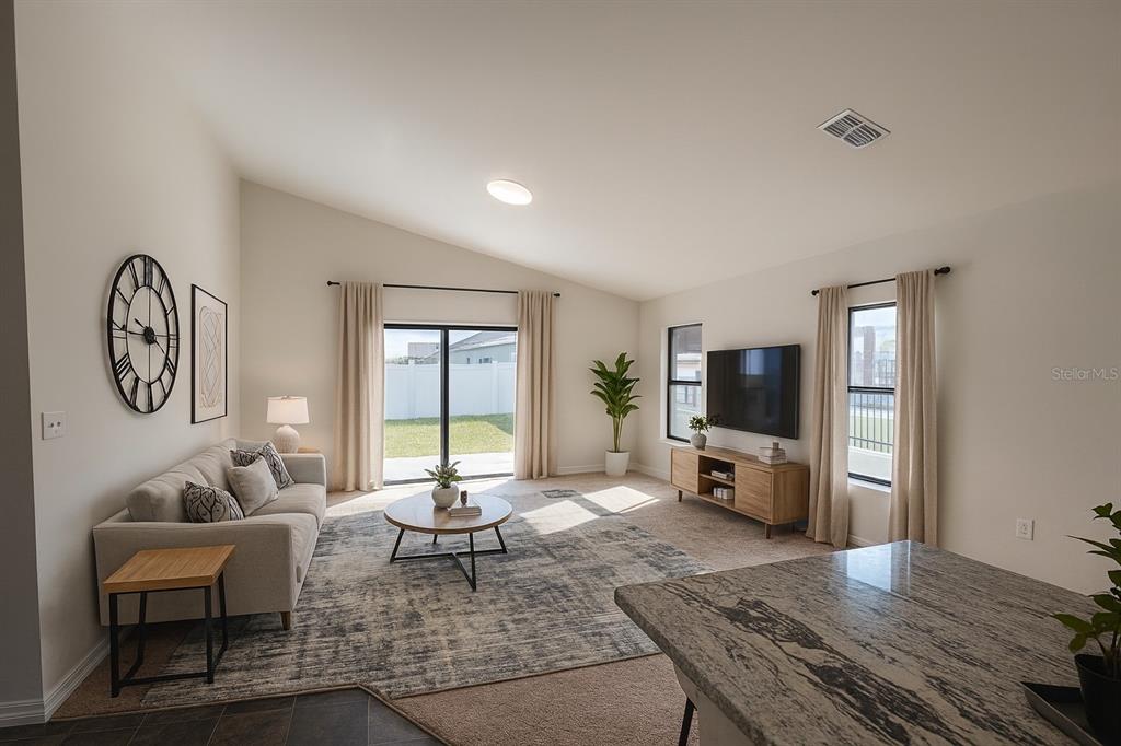 A living room features a beige sofa, a round coffee table, and a wall-mounted television — 540 CENTRAL RIDGE LANE, FROSTPROOF, FL