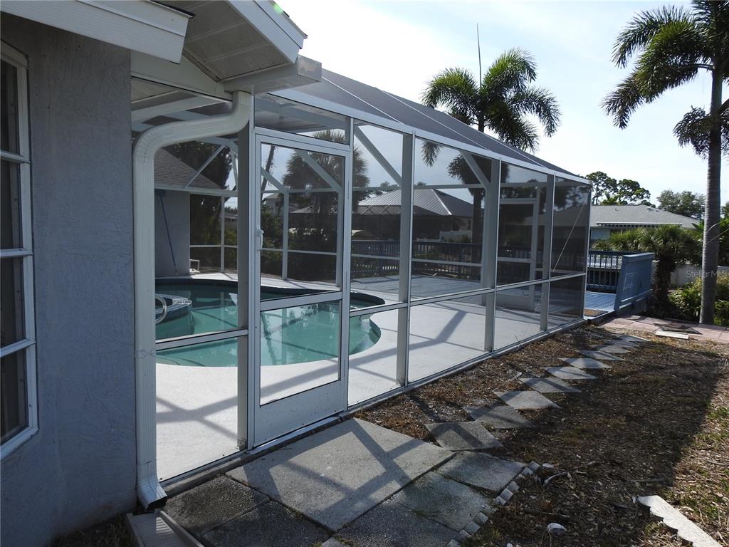 A screened-in pool enclosure is attached to the side of a residential home — 2132 PENNSYLVANIA AVENUE, ENGLEWOOD, FL
