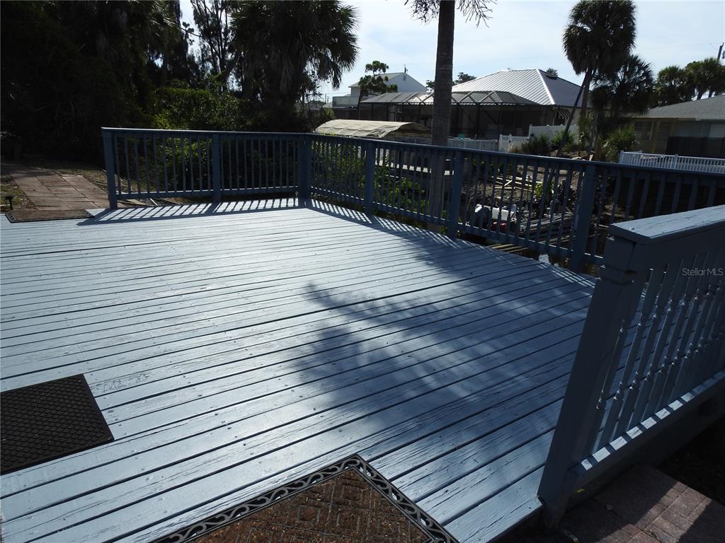 A light blue wooden deck features a railing and overlooks a canal with nearby houses — 2132 PENNSYLVANIA AVENUE, ENGLEWOOD, FL