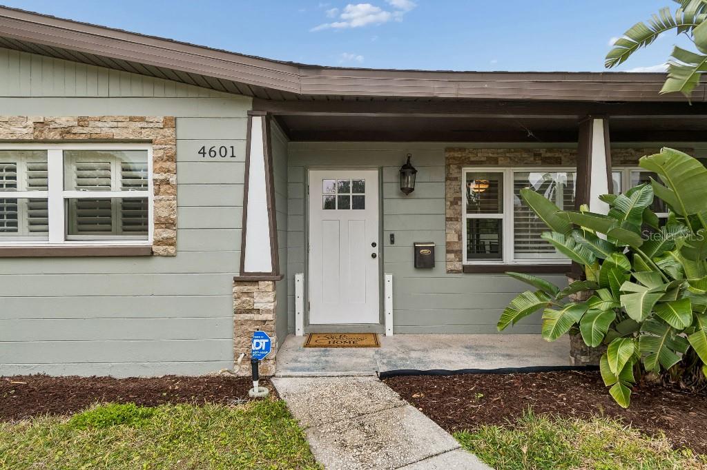 The exterior of a house features a white front door, stone accents, and a walkway — 4601 VENETIAN BOULEVARD NE, ST PETERSBURG, FL