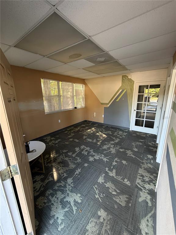 An office room features patterned carpet tiles, a drop ceiling, and a glass-paneled door — 15500 GEORGE BOULEVARD, CLEARWATER, FL
