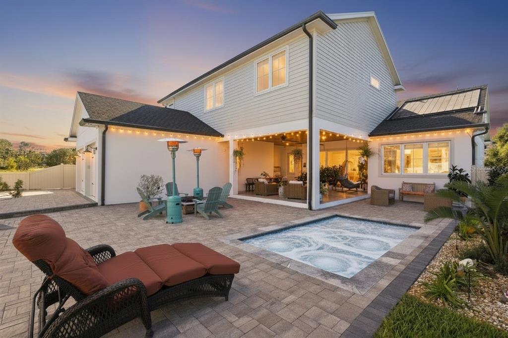 A backyard patio features a small pool, lounge chairs, and a covered outdoor living area — 3705 RIDGE RUN DRIVE, MINNEOLA, FL