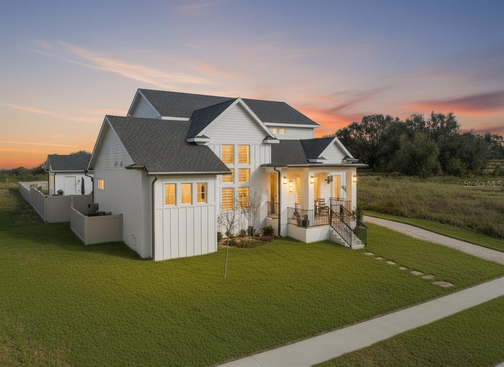 A two-story white farmhouse with a dark shingled roof sits on a grassy lot — 3705 RIDGE RUN DRIVE, MINNEOLA, FL