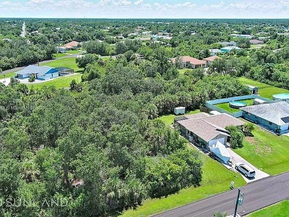 An aerial view shows a wooded lot next to a house with a swimming pool — 6264 BROOKRIDGE STREET, ENGLEWOOD, FL