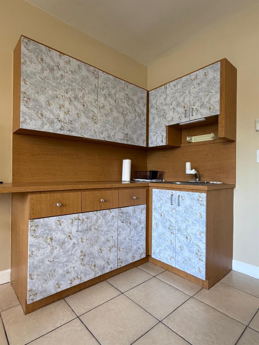 A kitchen corner features wood-tone cabinetry with marble-patterned doors and a stainless steel sink — 26 Diplomat Parkway, FL 33009, FL