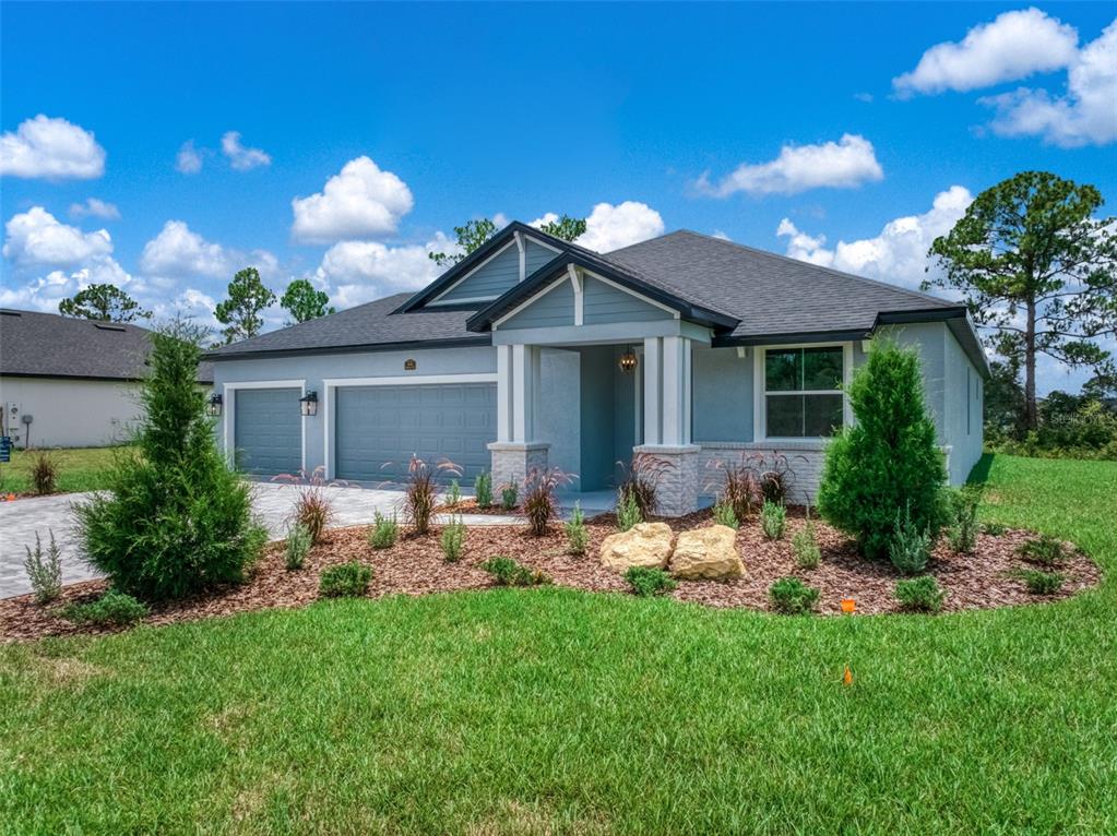 A single-story house with a gray exterior, a two-car garage, and a covered front porch — 4659 MIGNON DRIVE, SEBRING, FL