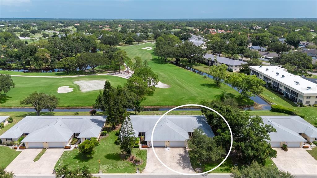 An aerial view shows a single-story residential building with a circled unit and golf course — 5621 PALM AIRE DRIVE, SARASOTA, FL