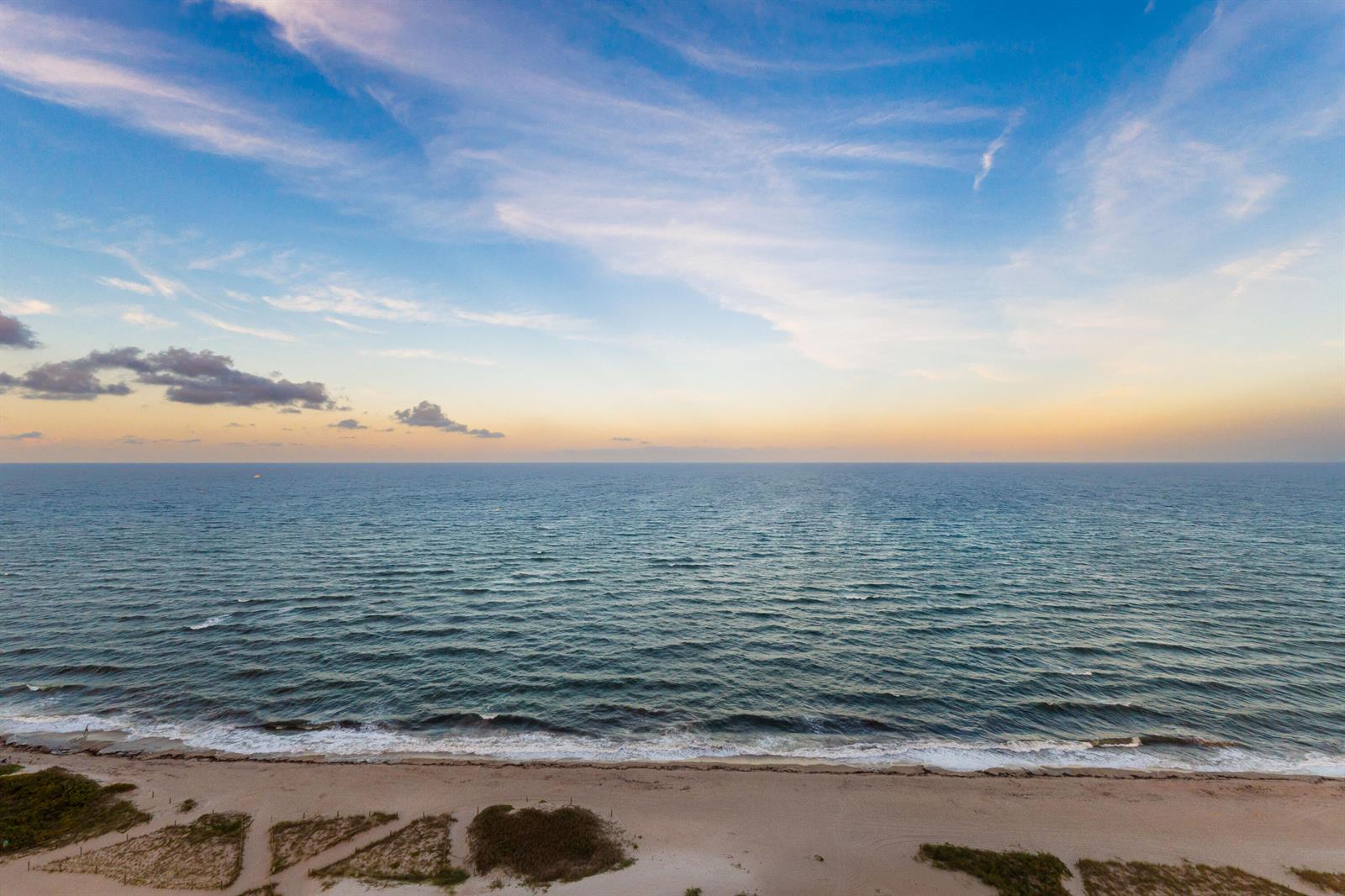 An aerial view of a sandy beach meeting the ocean under a sunset sky — 900 N Ocean Boulevard # 1904, Pompano Beach FL 33062, POMPANO BEACH, FL