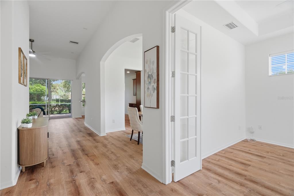 A view from a room with French doors looking toward a dining area and patio — 27325 MISTFLOWER DRIVE, WESLEY CHAPEL, FL