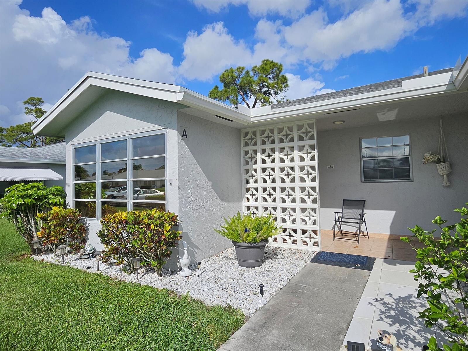 A single-story house exterior features a white breeze block screen, large windows, and landscaping — 14628 Canalview Drive # A, Delray Beach FL 33484, DELRAY BEACH, FL