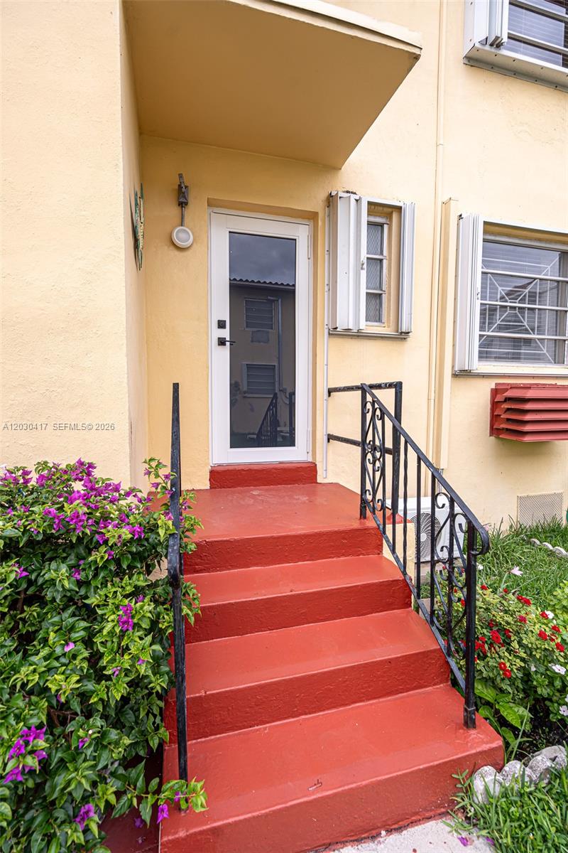 The exterior of a building features a red concrete staircase leading to a white door — 637 SW 11th St # 6W, Miami FL 33129, MIAMI, FL