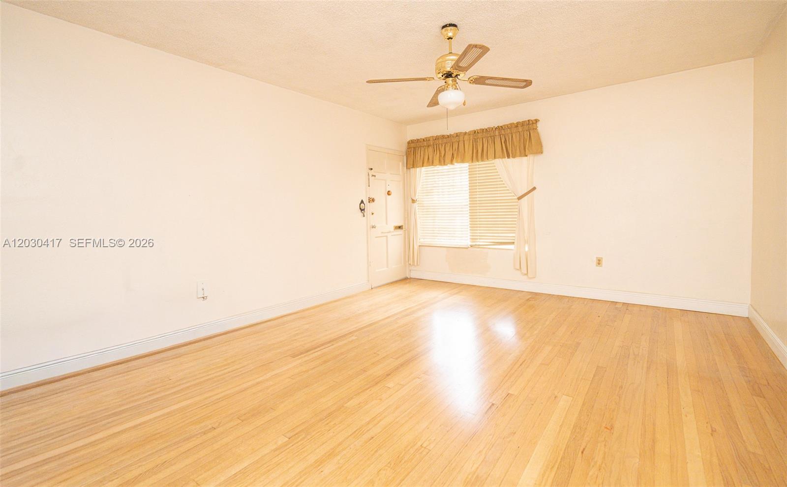 An empty room features light wood flooring, a ceiling fan, and a window with curtains — 637 SW 11th St # 6W, Miami FL 33129, MIAMI, FL