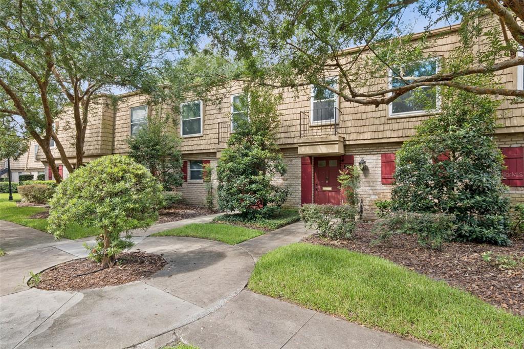 A two-story townhouse exterior with brick siding, red shutters, and a front walkway — 200 SAINT ANDREWS BOULEVARD UNIT 2904, WINTER PARK, FL