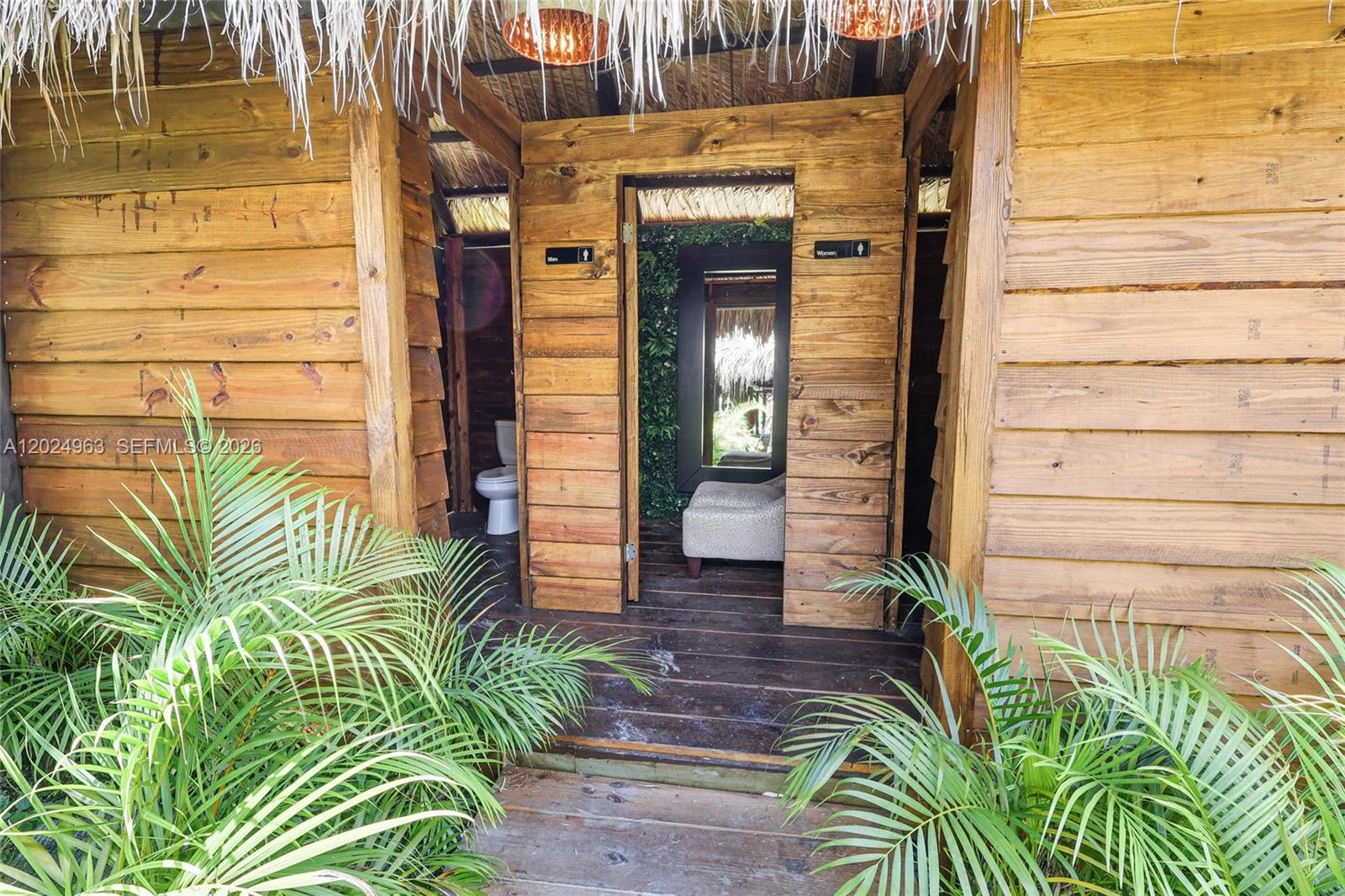 A wooden outdoor structure features separate men's and women's restroom entrances with tropical foliage — 14701 SW 199th Ave, Miami FL 33196, MIAMI, FL