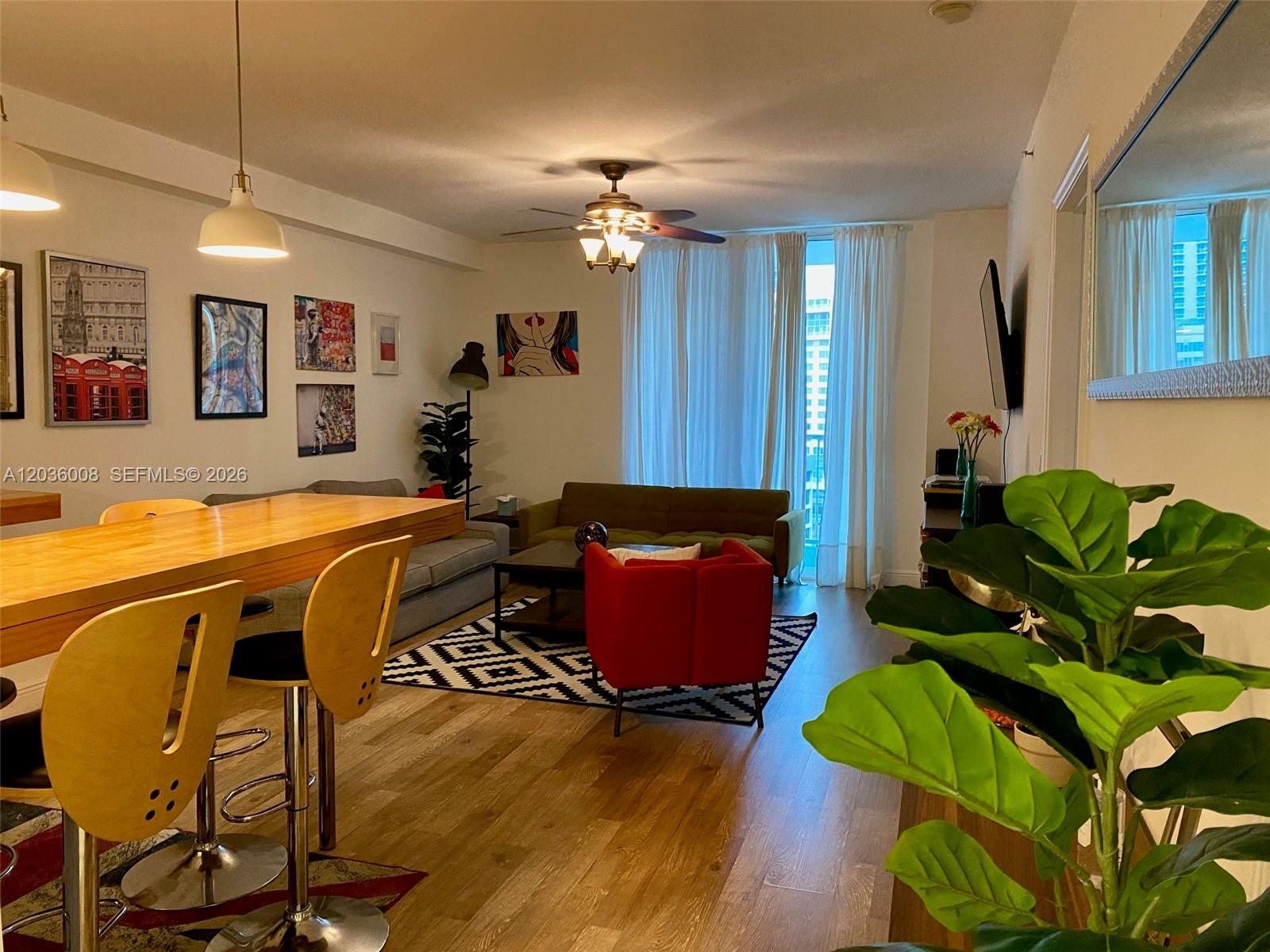 A living room features a dining bar, a red armchair, and a sofa on wood floors — 1250 S Miami Ave # 1312, Miami FL 33130, MIAMI, FL