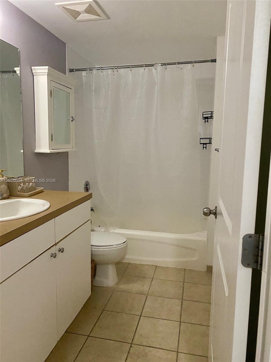 A bathroom features a white vanity, a toilet, and a shower-tub combination with a curtain — 1250 S Miami Ave # 1312, Miami FL 33130, MIAMI, FL