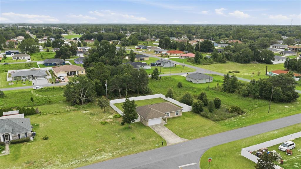 An aerial view shows a suburban house with a fenced backyard and a paved driveway — 4801 145TH PLACE, OCALA, FL
