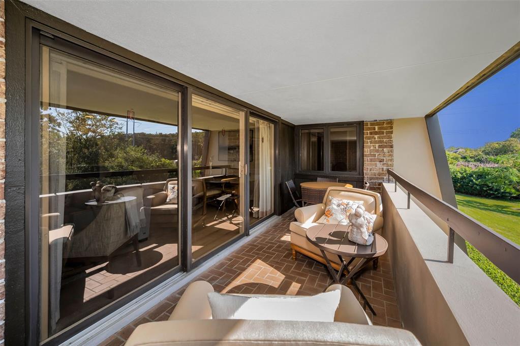 A balcony with brick flooring, outdoor furniture, and a sliding glass door entrance — 36750 US HIGHWAY 19 N UNIT 28-2017, PALM HARBOR, FL
