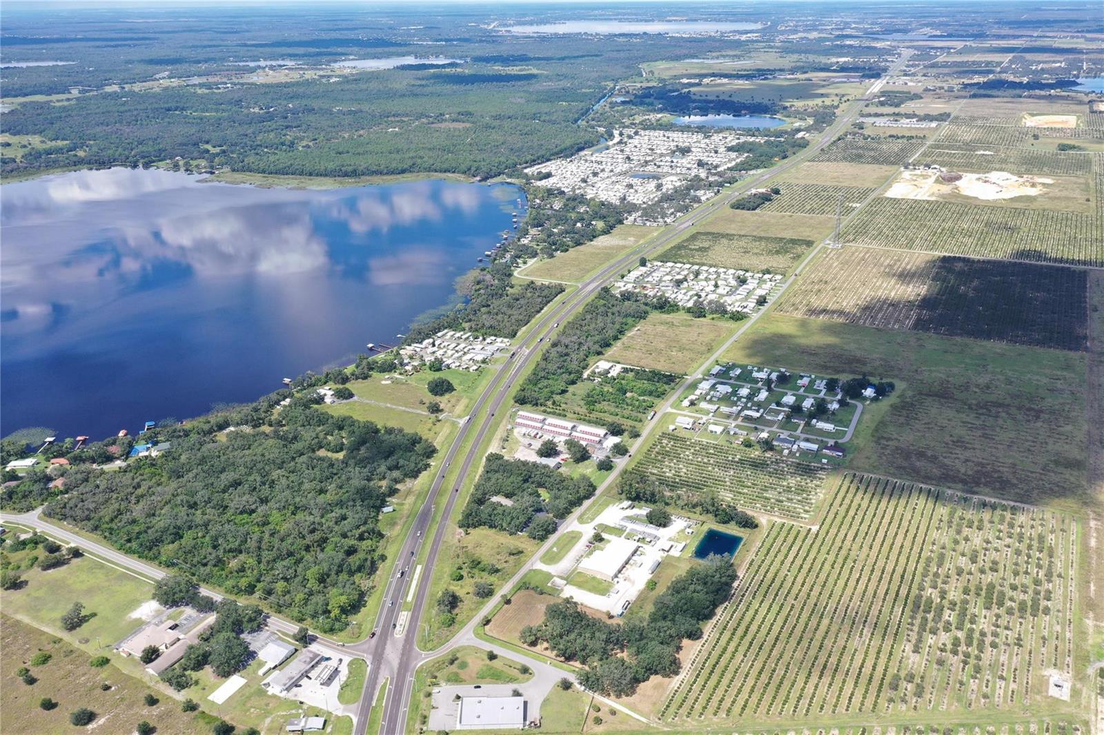 An aerial view shows a highway running alongside a large lake and agricultural fields — 11400 Us-27, Sebring FL 33876, SEBRING, FL