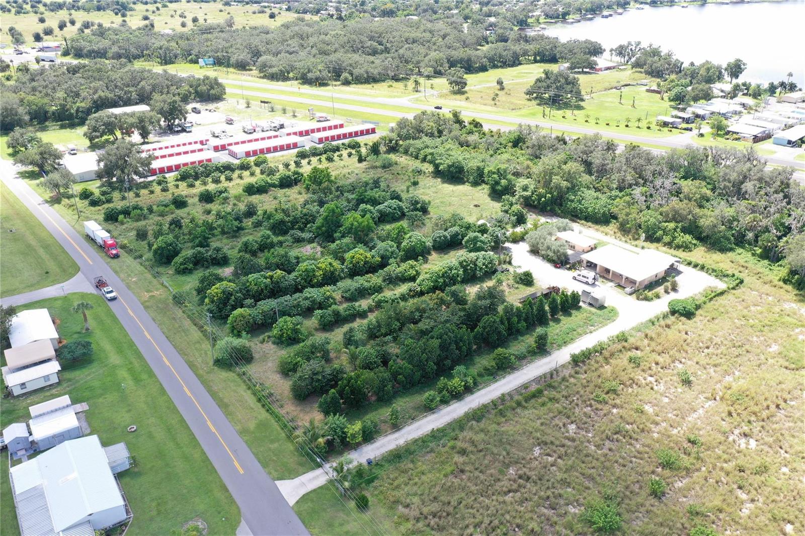 An aerial view shows a rural property with a house, orchard, and adjacent storage units — 11400 Us-27, Sebring FL 33876, SEBRING, FL
