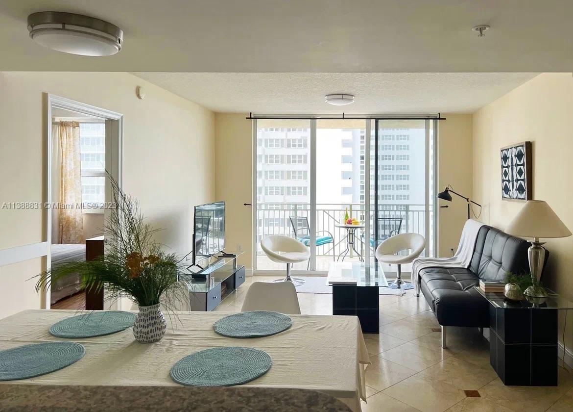 A living and dining area features tile floors, a black sofa, and a balcony view — 2080 S Ocean Dr # 806, Hallandale Beach FL 33009, HALLANDALE BEACH, FL