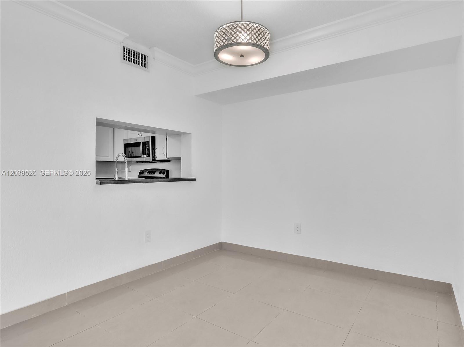 A dining area features tile flooring, a decorative light fixture, and a kitchen pass-through window — 2075 SW 122nd Ave # 304, Miami FL 33175, MIAMI, FL