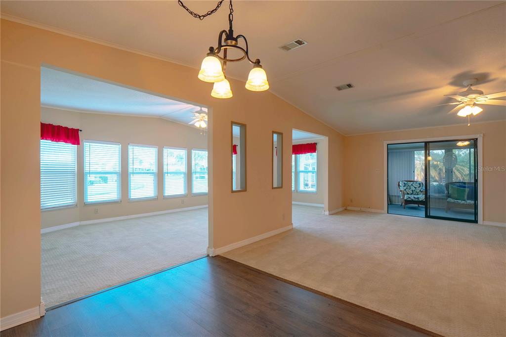 A view of a living area with carpeted floors, a chandelier, and a sliding glass door — 5910 MAJESTIC WAY, PALMETTO, FL