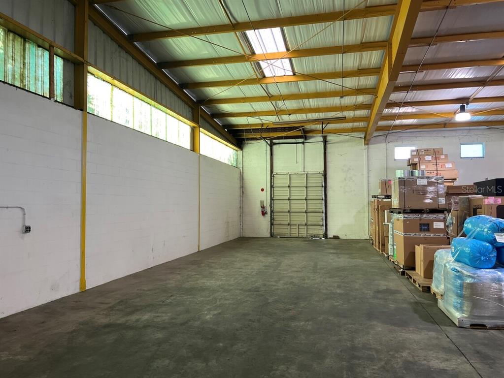 An industrial warehouse space features a concrete floor, white block walls, and a metal roof — 6625 ANDERSON ROAD, TAMPA, FL