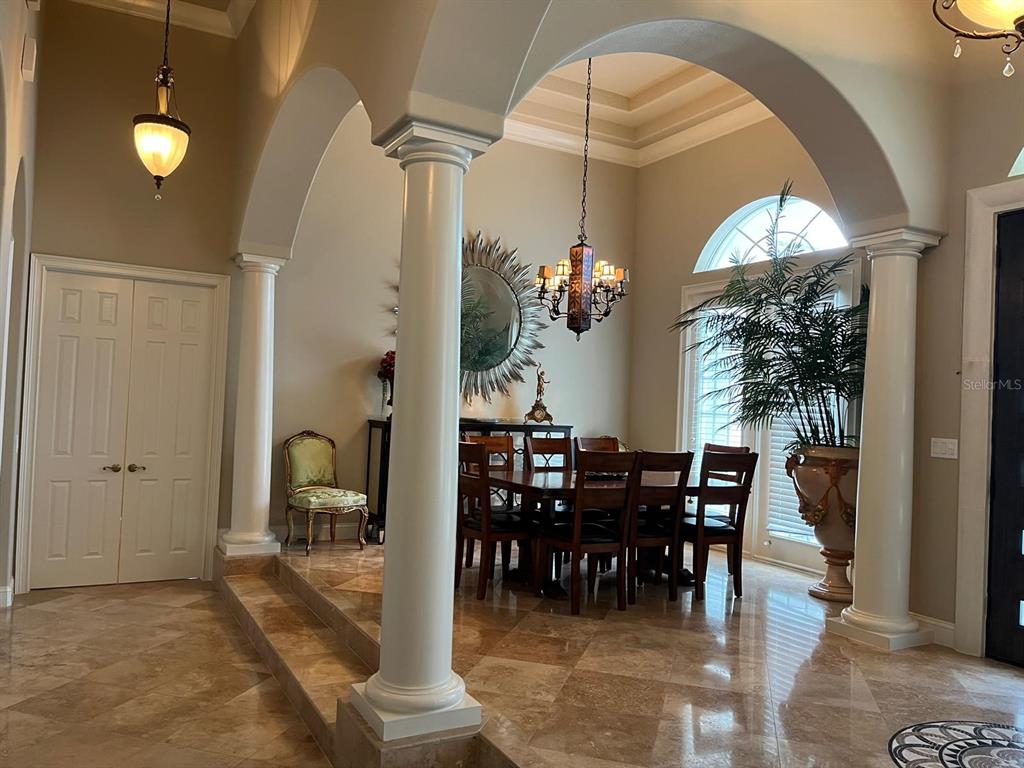 A dining room with a tray ceiling, columns, and tile flooring viewed from an entryway — 6354 CARTMEL LANE, WINDERMERE, FL
