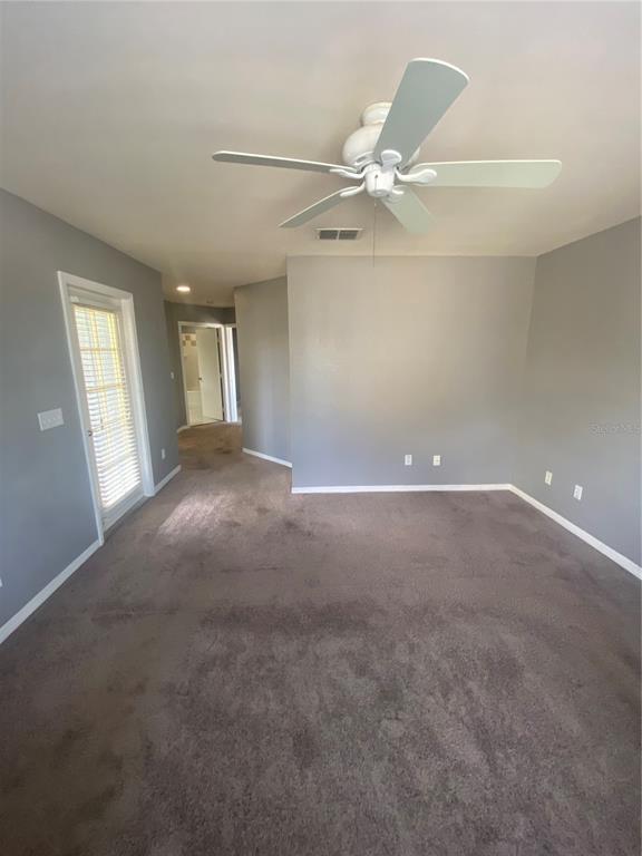 A bedroom with gray walls, carpeted flooring, a ceiling fan, and a glass door — 4009 SAND PALM COURT, TAMPA, FL