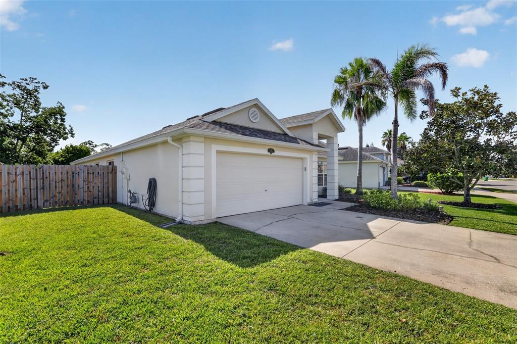 A single-story house with a two-car garage, a concrete driveway, and a wooden fence — 1763 SUN GAZER DRIVE, ROCKLEDGE, FL