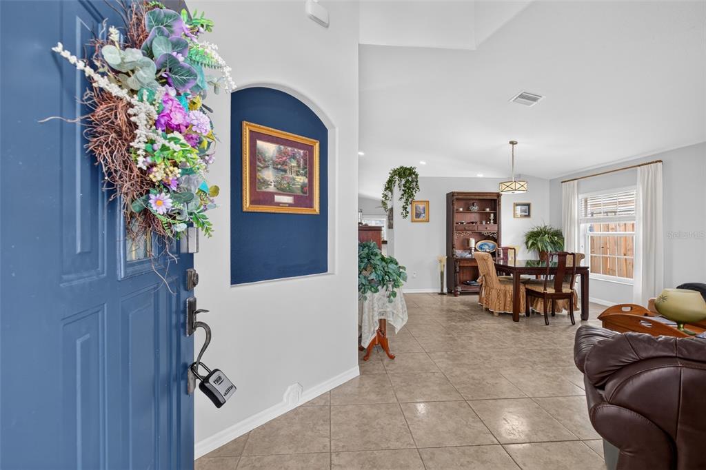 A view from an open blue front door into a tiled dining area and living space — 1763 SUN GAZER DRIVE, ROCKLEDGE, FL