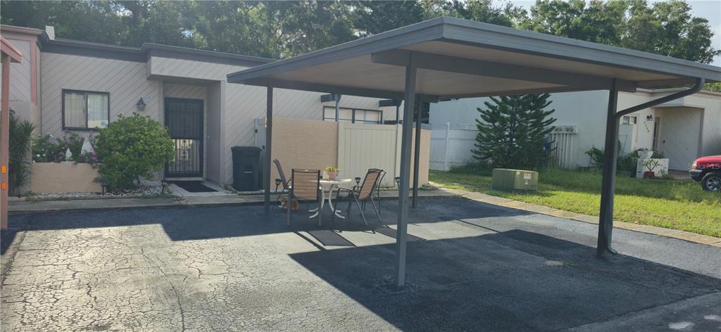 A single-story residence with a carport, a small patio set, and a paved driveway — 2214 OAK WIND DRIVE, HOLIDAY, FL