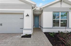 The exterior of a house features a white stucco facade, a blue front door, and a garage — 44393 Kelly Drive, Punta Gorda FL 33982, PUNTA GORDA, FL