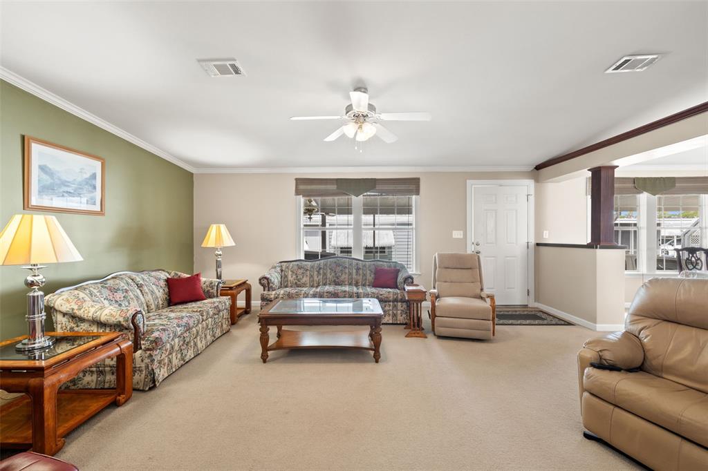 A living room features two floral sofas, a beige recliner, and a central coffee table — 82085 1ST AVENUE N UNIT 85, PINELLAS PARK, FL