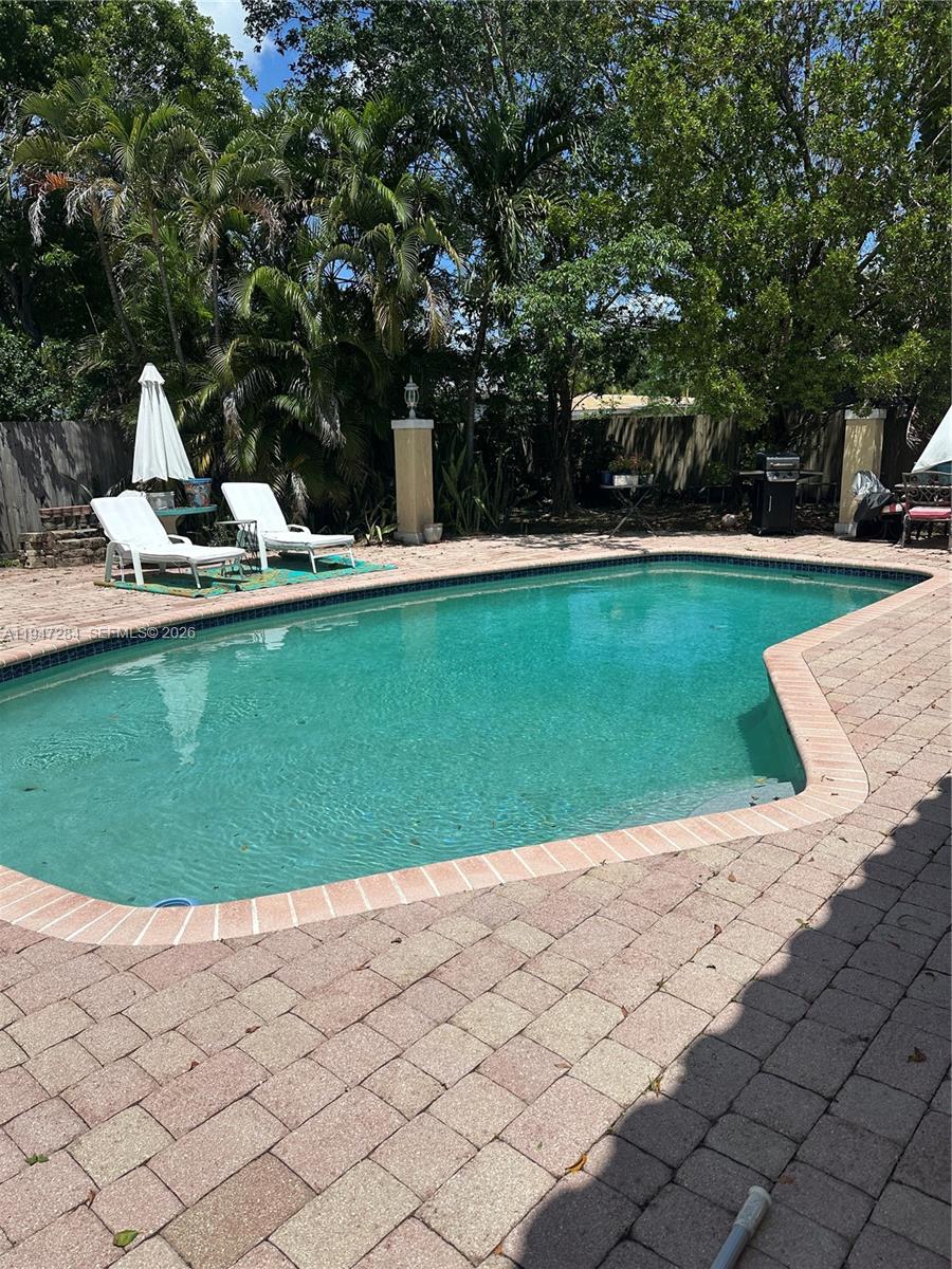 A bedroom features a bed with a gold headboard, a mirror, and a wicker bench — 2501 NE 22nd St, Pompano Beach FL 33062, POMPANO BEACH, FL