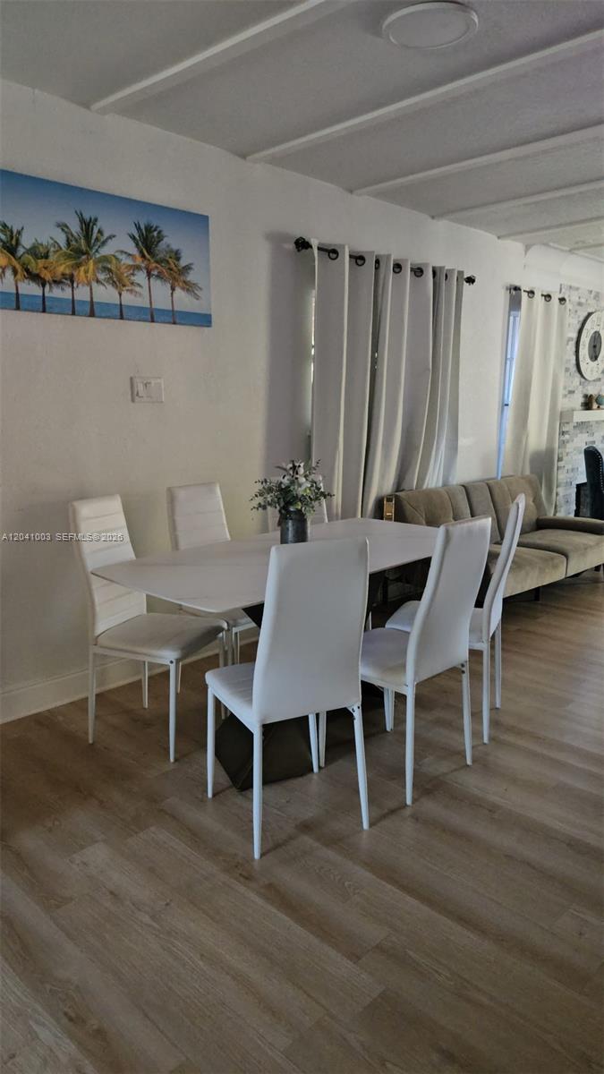 A dining area features a white table with four white chairs on wood-look flooring — 570 NW 97th St, Miami FL 33150, MIAMI, FL